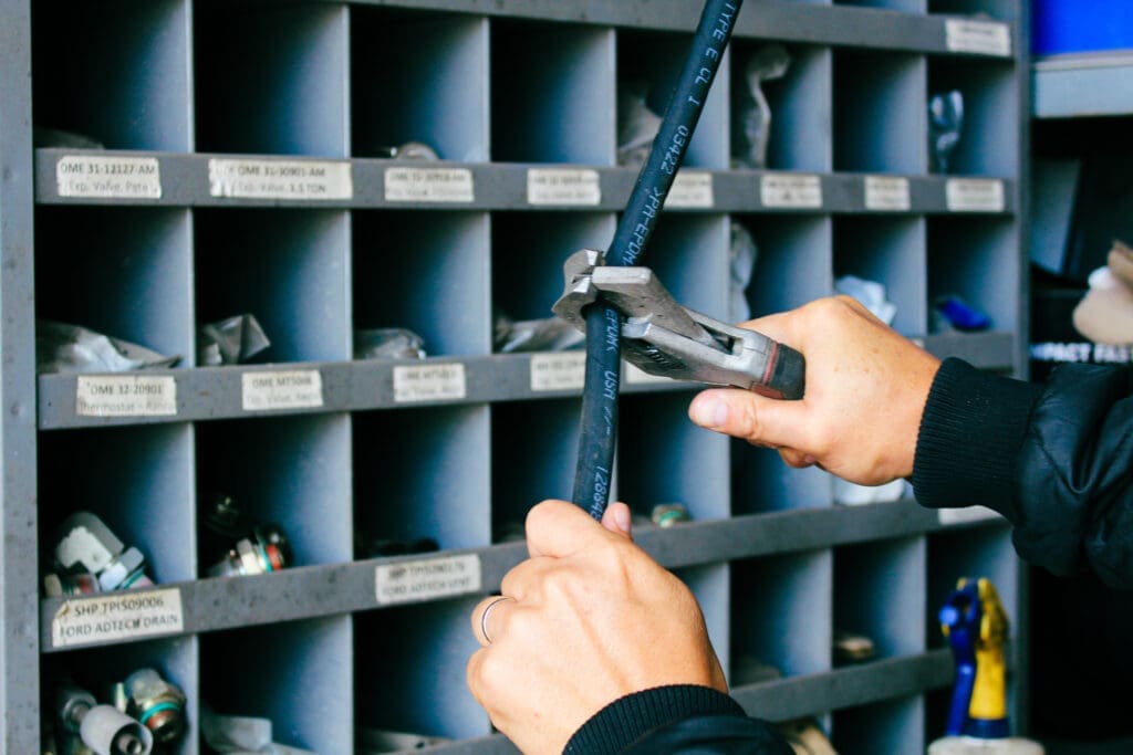 Shop tech holding aftermarket A/C line